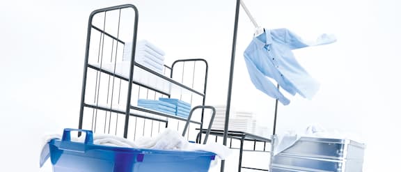 Accessoires pour lave-linge et sèche-linge professionnels dans une buanderie.
