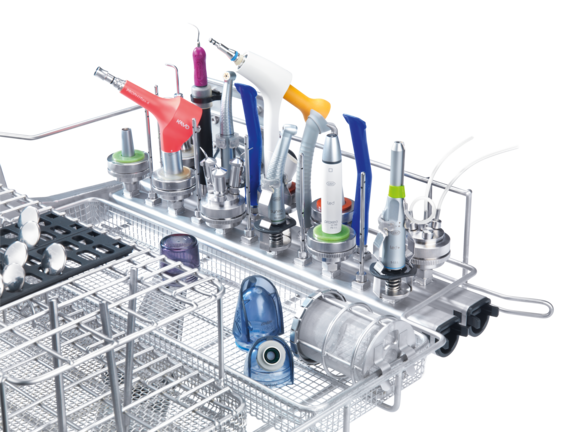 Różne narzędzia stomatologiczne umieszczone w górnym koszu urządzenia myjącego i dezynfekującego.