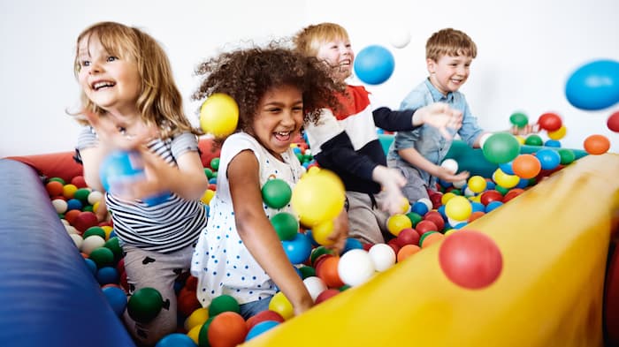 Bambini che giocano in una vasca con palline colorate.