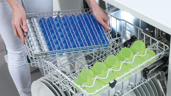 Uma máquina de lavar louça Miele Professional é equipada com complementos correspondentes para recipientes para comprimidos.