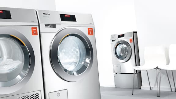 Máquinas de lavar roupa e secadores com appWash na sala de lavandaria.