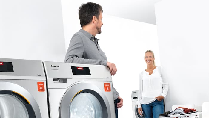 Two adults talk in a washroom operated by appWash.