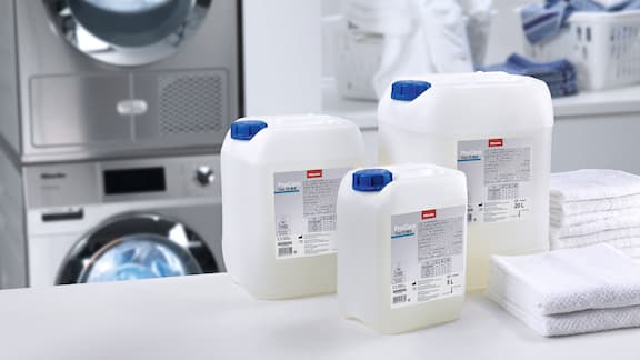 Bidon de ProCare Tex, à côté des serviettes, de la machine à laver et du panier à linge.
