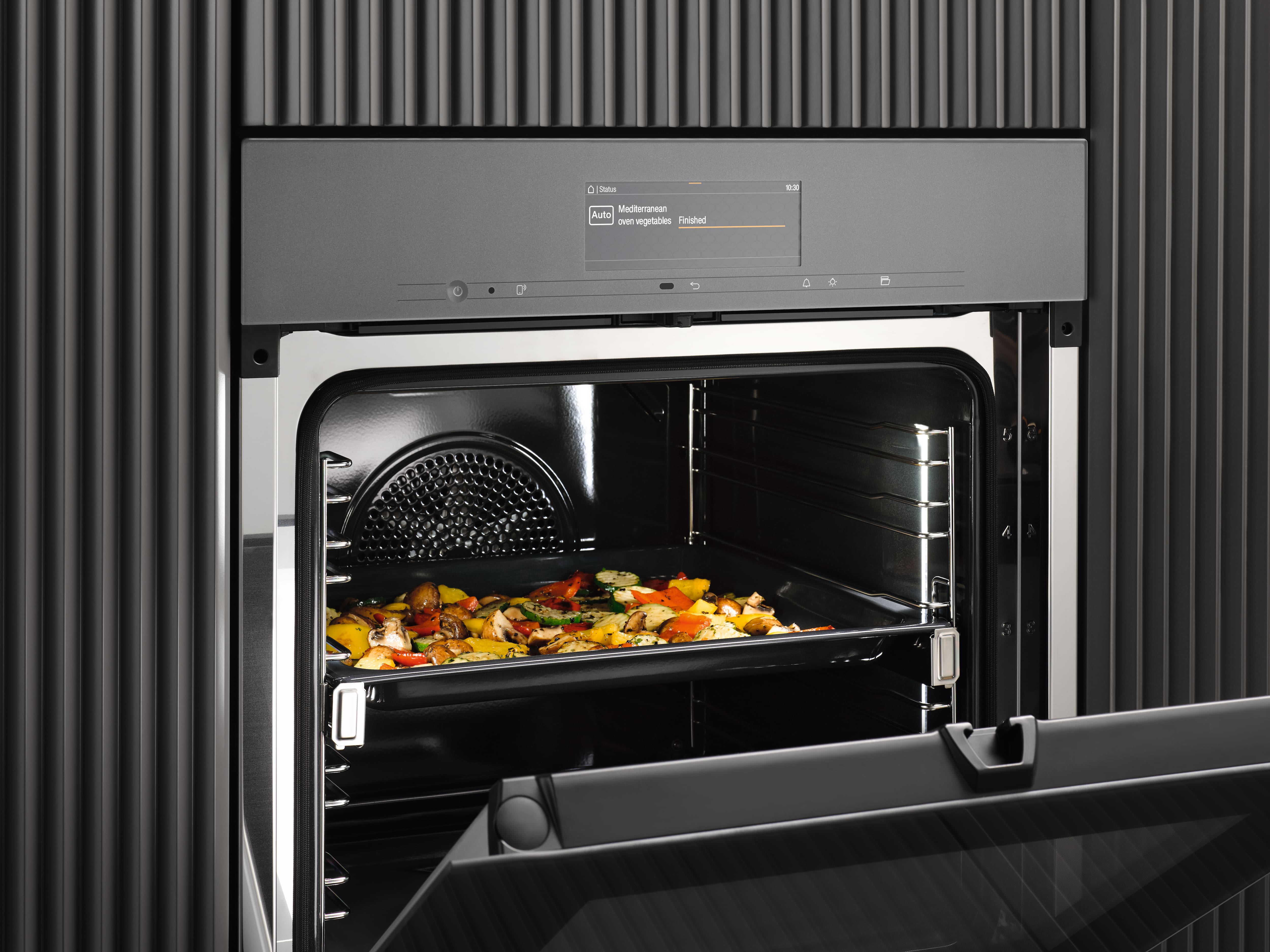 Miele tray coming out of the oven with a cake on it