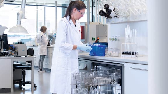 An Dr. Oetker employee stands in the company's research and development centre, putting away a Miele laboratory dishwasher.