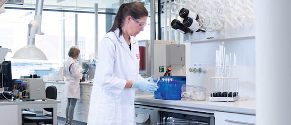 Laboratory technician holds laboratory glassware in her hand.