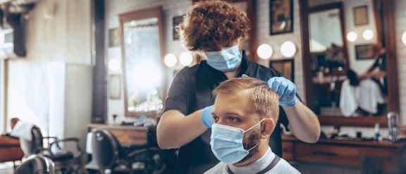 Hairdresser cuts a customer’s hair.