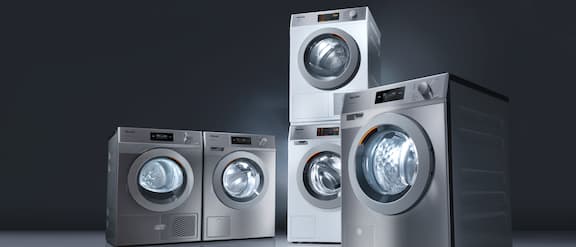 Packshot de cinco máquinas de lavar roupa industriais profissionais.
