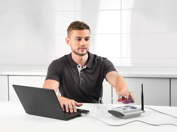 Service technician carries out a test using a laptop and accessories.