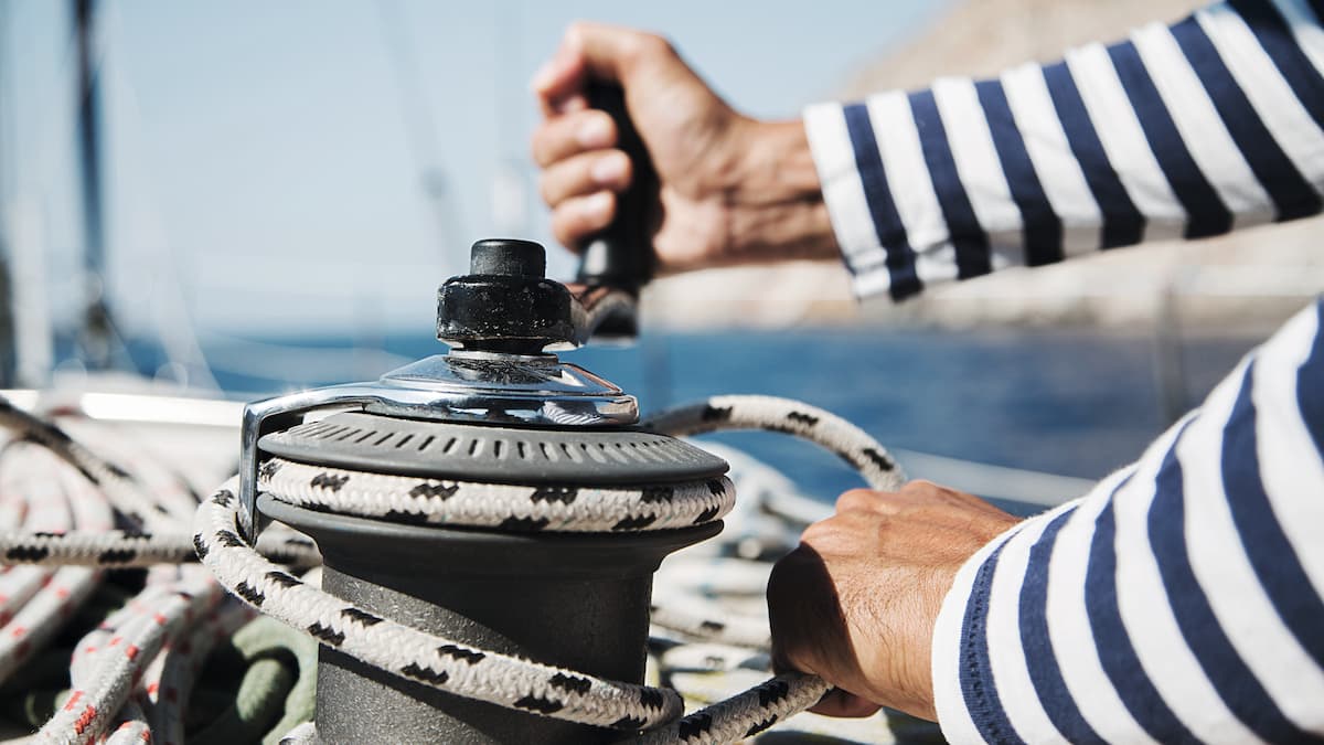 Sailor handles a rope on a sailing boat.