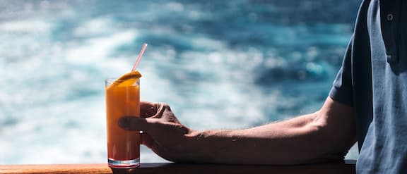 Vakantieganger drinkt een cocktail op een cruiseschip