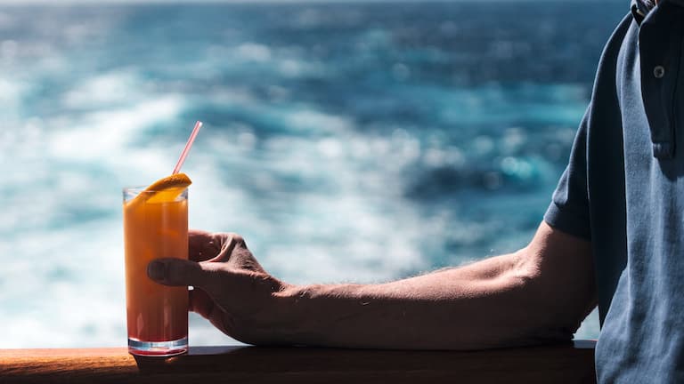 Gość na jachcie trzyma koktajl