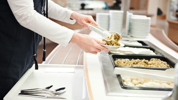 Hands help themselves in a catering environment.