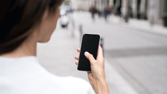 A lady's hand carries a smartphone in her hand 