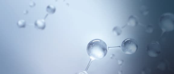 En servicetekniker knæler foran en SlimLine-laboratorieopvaskemaskine og sætter en doseringslanse i en ProCare Lab-dunk.