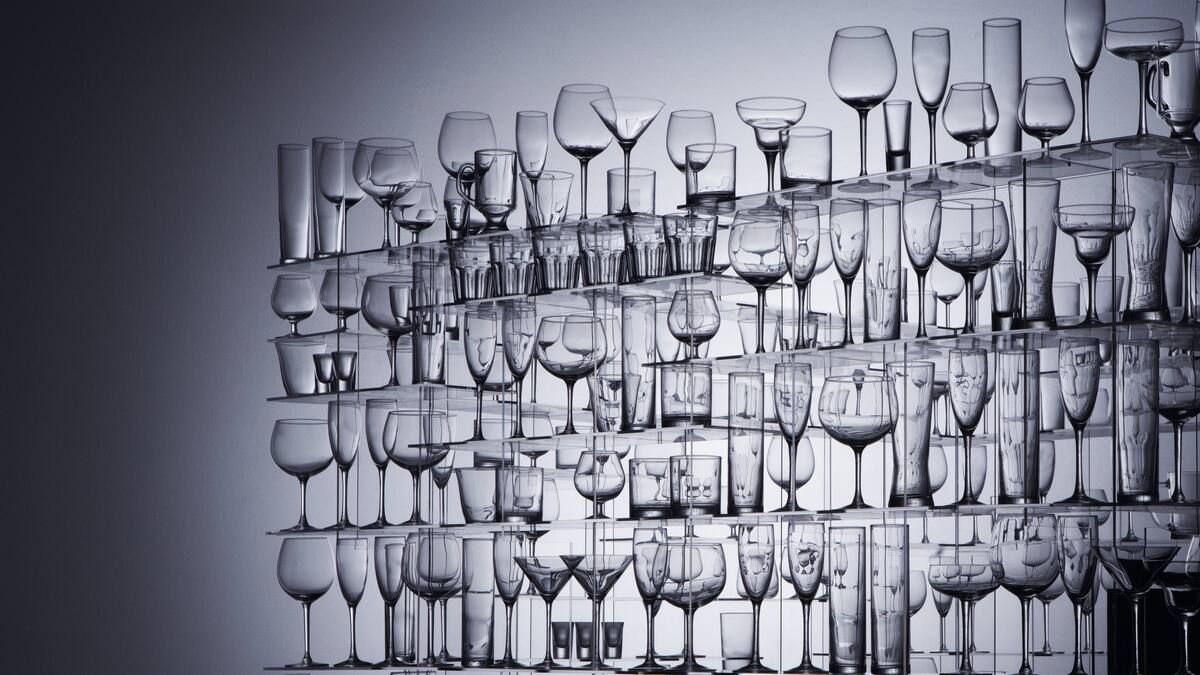 A large stack of glasses against a dark background