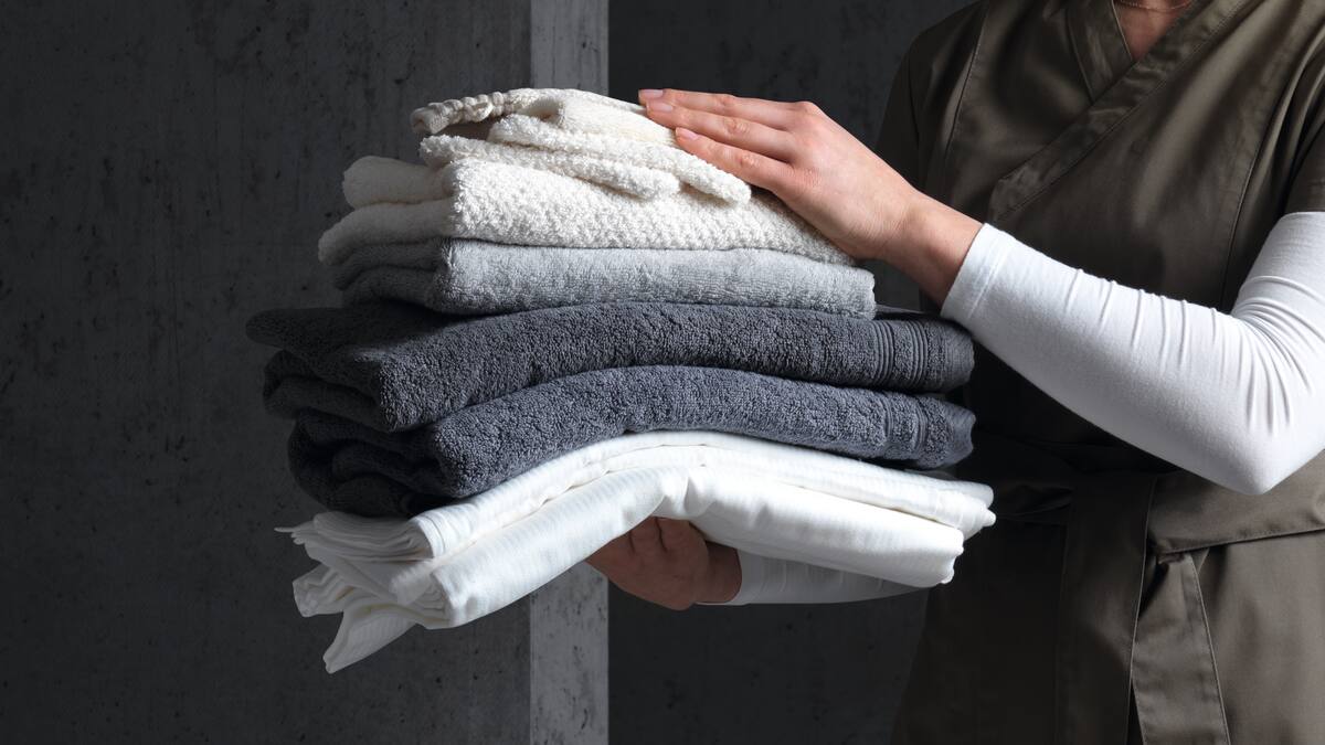 Una donna regge asciugamani lavanti impilati