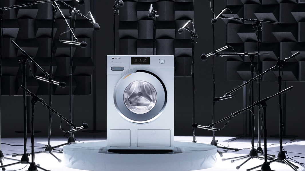A Miele washing machine surrounded by microphones