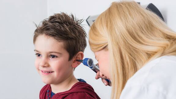 Un petit garçon est soumis à un examen de l’oreille.