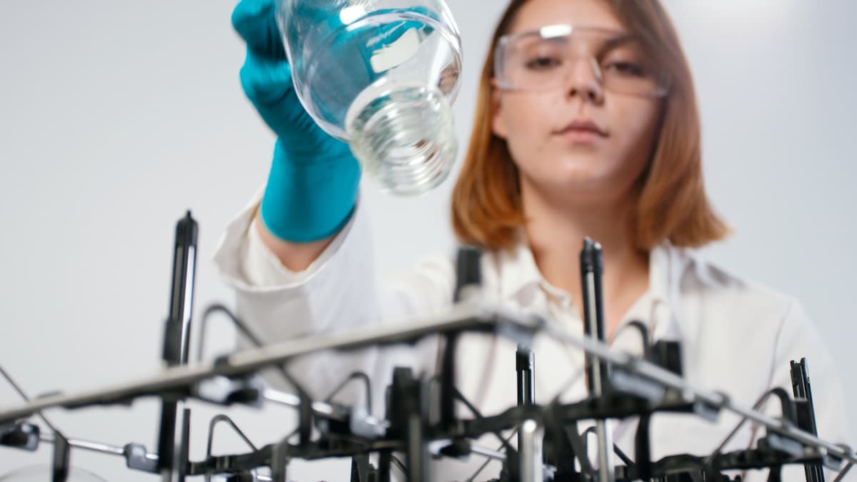 Eine Frau im Labor belädt die Glaswaschmaschine