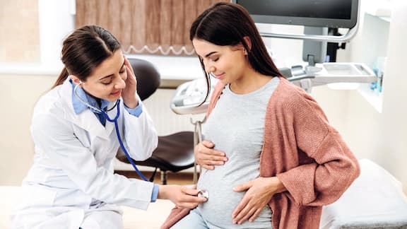 Uma mulher grávida é examinada por uma ginecologista.