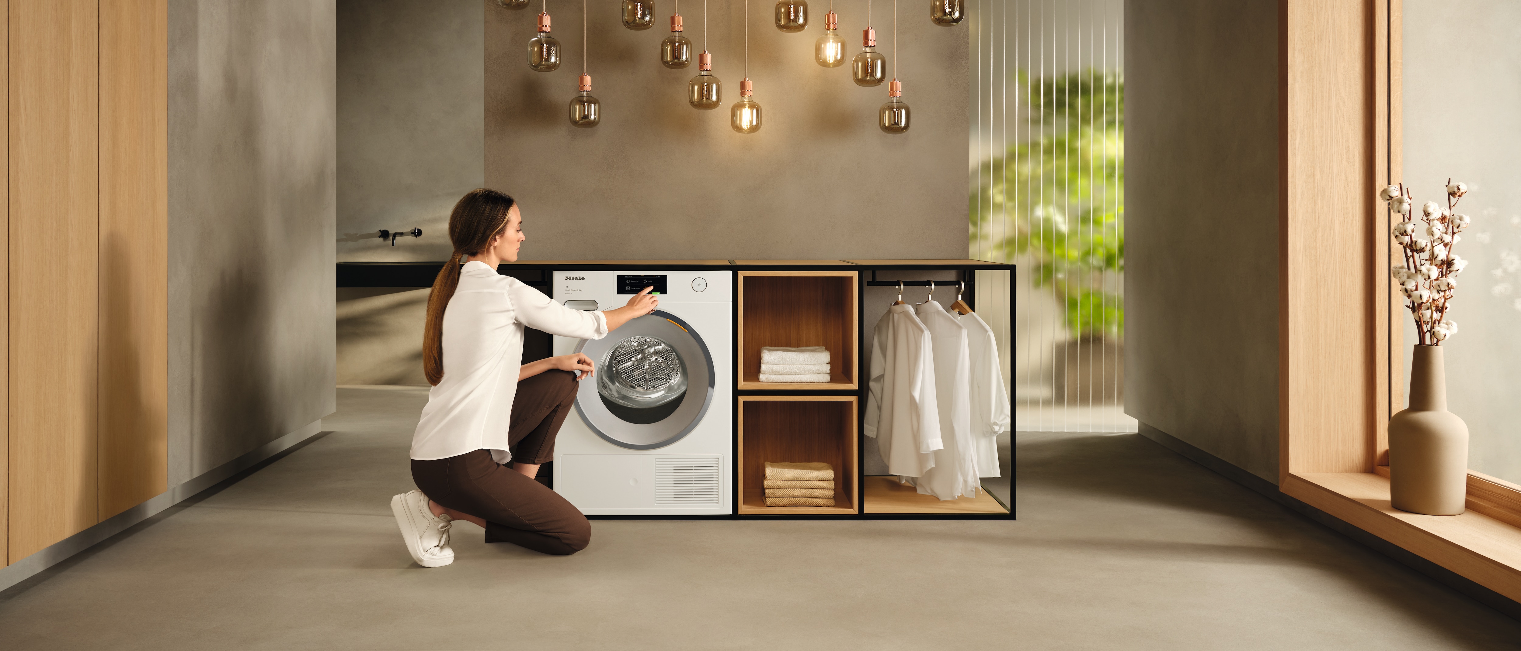 A woman adjusting the setting on the Miele dryer with EcoDry