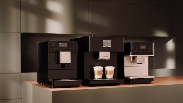 All three models of Miele coffee machines on display on a kitchen countertop