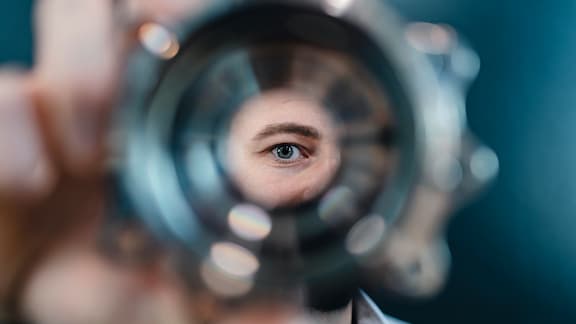 A man looks through the hole of a component.
