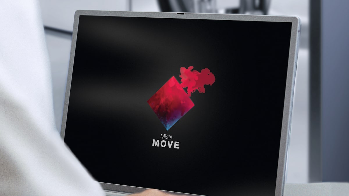 Iemand zit achter de laptop met het logo van Miele MOVE op het scherm