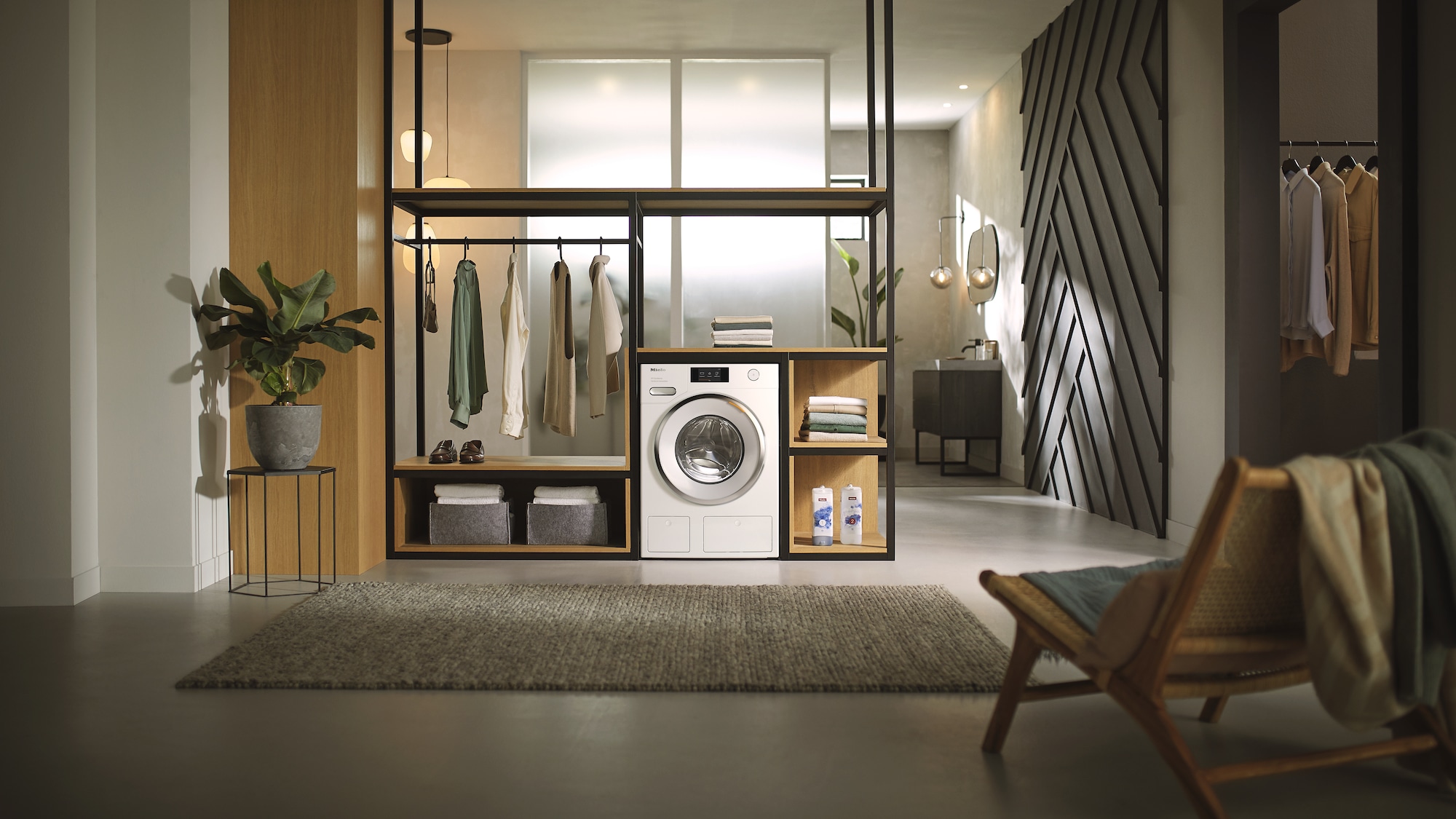 White Washing machine pictured in the laundry nook of a stylish home with hanging garments and detergent on display