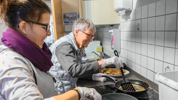 Zwei Personen kochen miteinander.