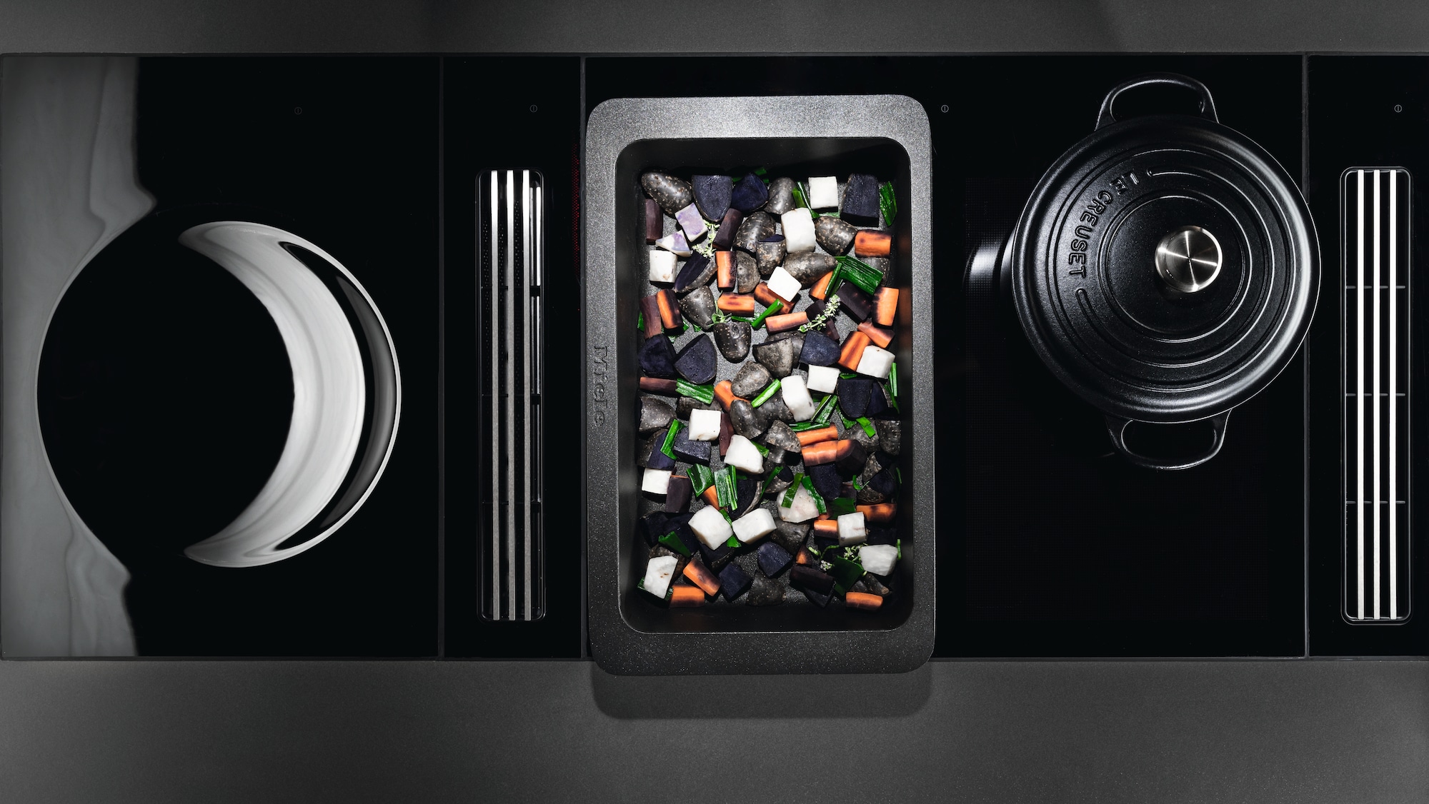 Chef hands using tweezers to edit vegtables on a metal tray