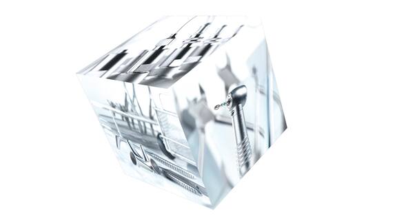 É visível um cubo com diferentes motivos fotográficos. Estão ilustrados diversos instrumentos médicos.