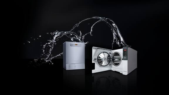 Ein Cube Sterilisator und ein Thermodesinfektor stehen vor einem schwarzen Hintergrund, wo im Hintergrund ein Wasserelement die beiden Geräte verbindet.