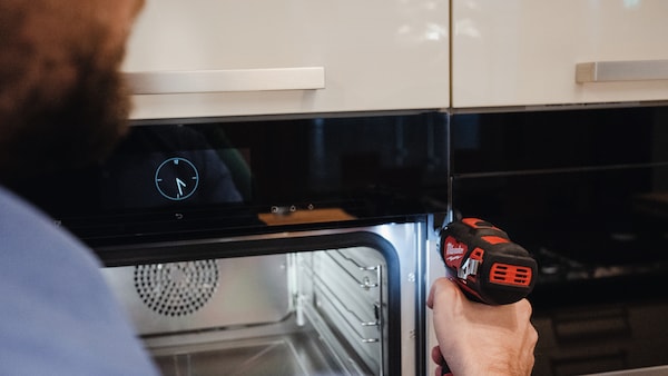 man repairing Miele built in oven