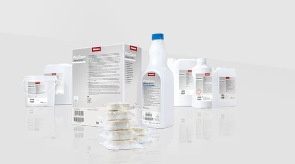 Différents produits chimiques de nettoyage et de rinçage en poudre, liquide ou tablettes de la gamme ProCare Shine sur un fond gris