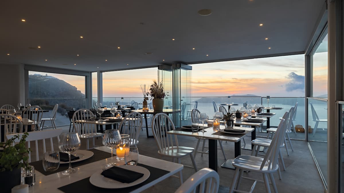 The restaurant of the Hotel Rocabella on Santorini. The view is of a sunset by the sea. 