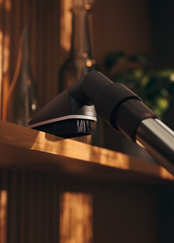 A woman looking at her phone while leaning on a kitchen bench