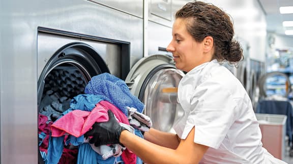 An employee loads a washing machine