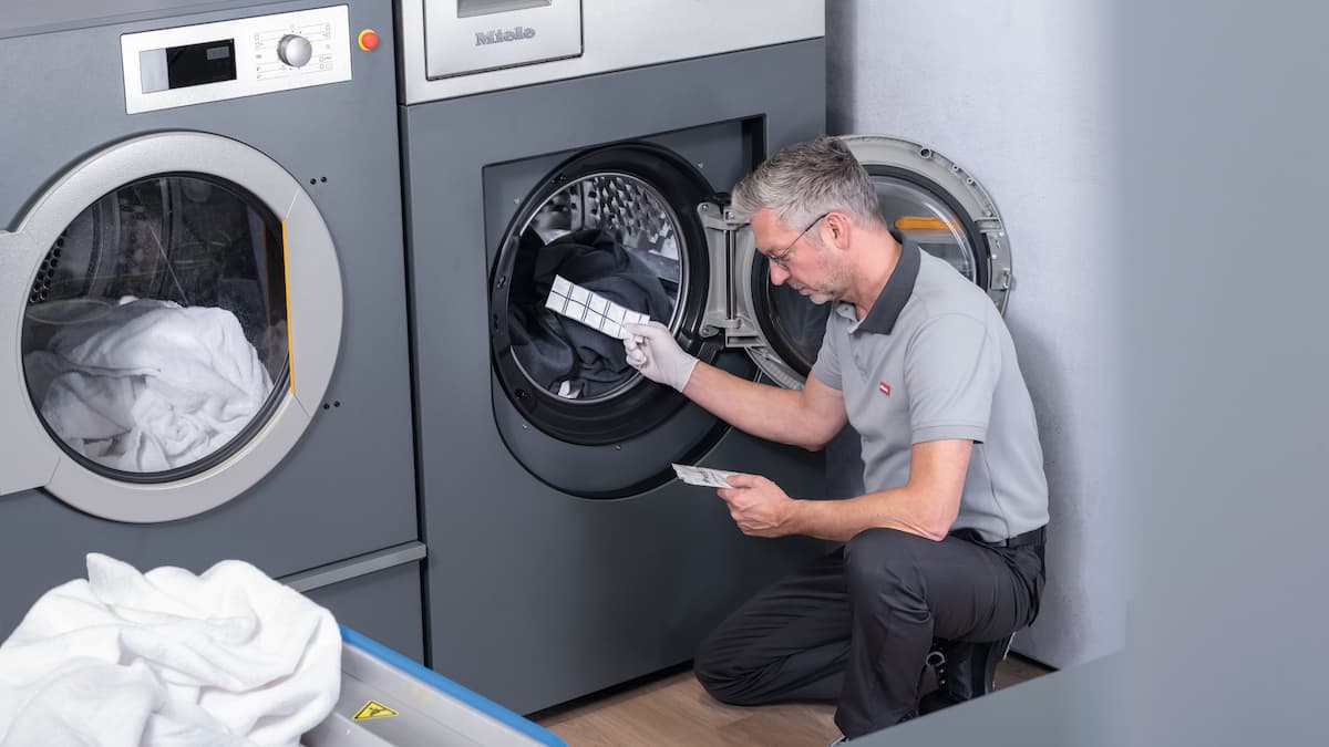 Il tecnico dell'assistenza inserisce una striscia reattiva ProHygiene nel tamburo di una lavatrice