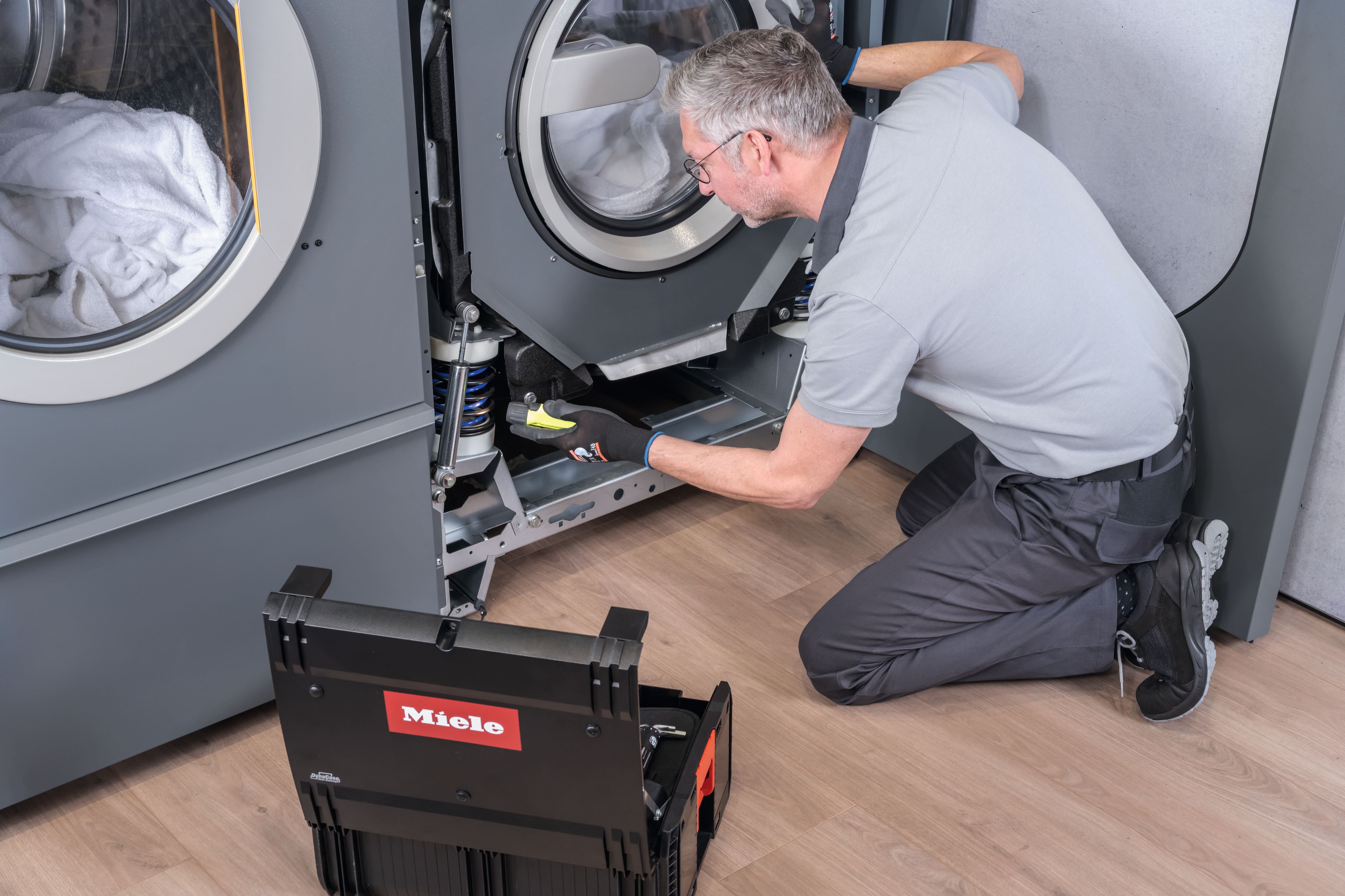 Service technician inspects a machine and performs maintenance.