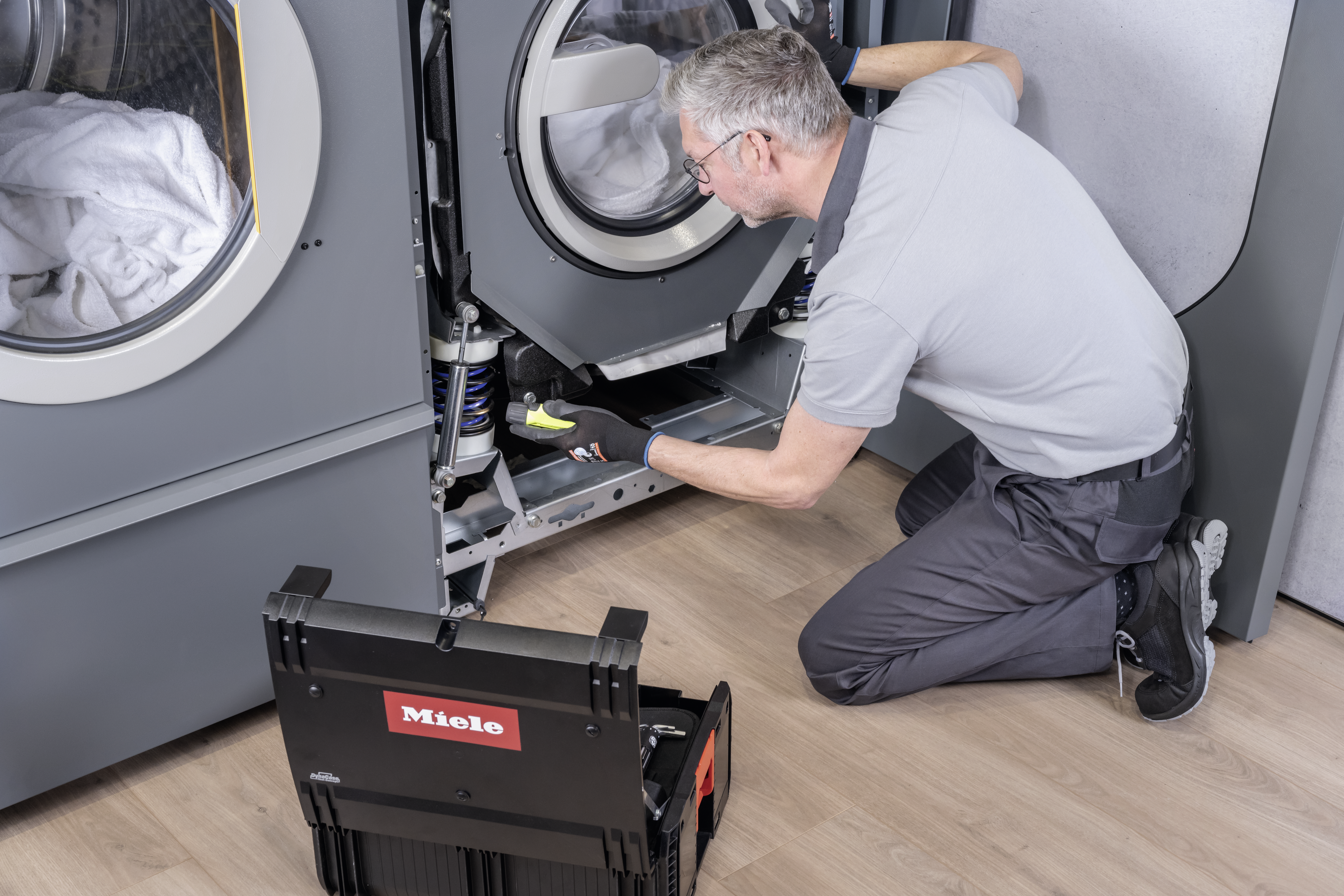 Service technician inspects a machine and performs maintenance.