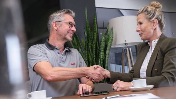 Bir servis teknisyeni bir müşteri ile görüşme sırasında el sıkışıyor