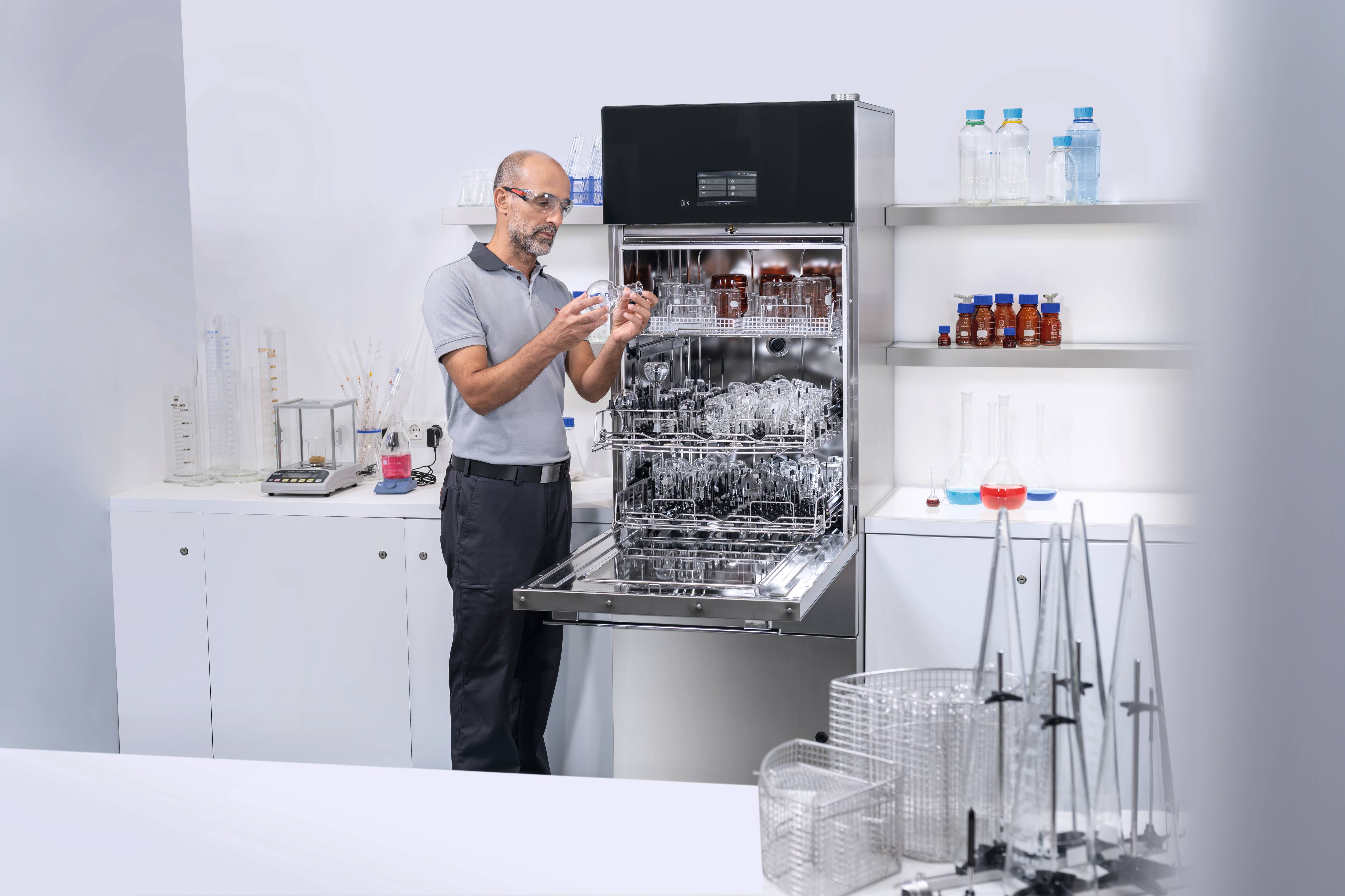 Ein Miele Service-Mitarbeiter prüft den Sprüharm eines SlimLine Laborspülers PLW 7111 in einem Laborraum.