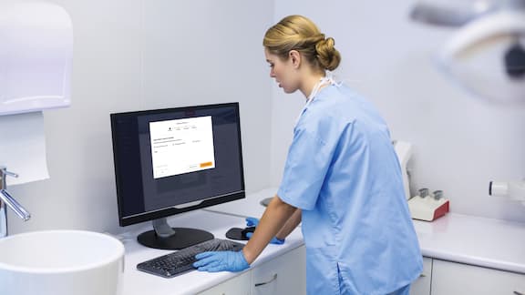 Un chirurgien dentaire devant un ordinateur