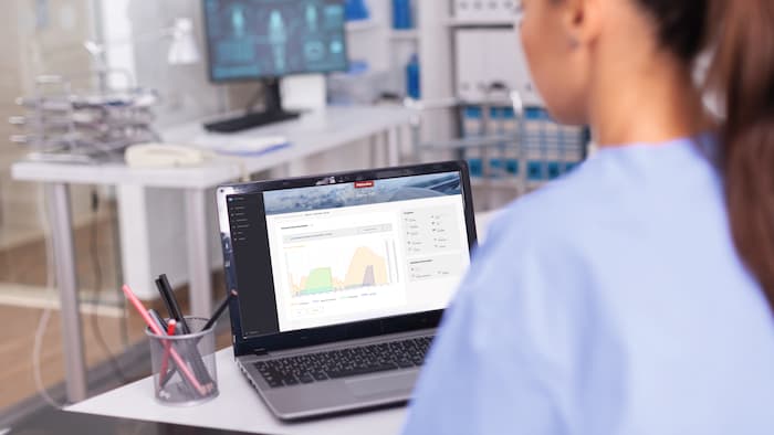 Henkilö työskentelee kannettavalla tietokoneella, jonka näytöllä näkyy Miele MOVE MedDent+ -ohjelman prosessitietojen arviointi.