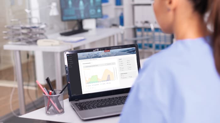 A laptop in a doctor's surgery shows a visual representation of programme data.