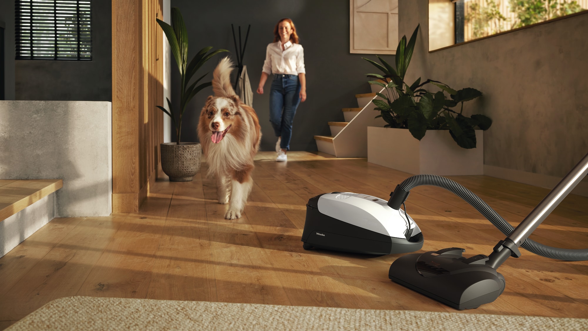 White canister vacuum with woman and dog in background