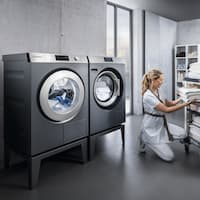 Commercial washing machines save time and energy – for example, while an employee in a hotel laundry sorts towels