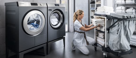 Commercial washing machines save time and energy – for example, while an employee in a hotel laundry sorts towels